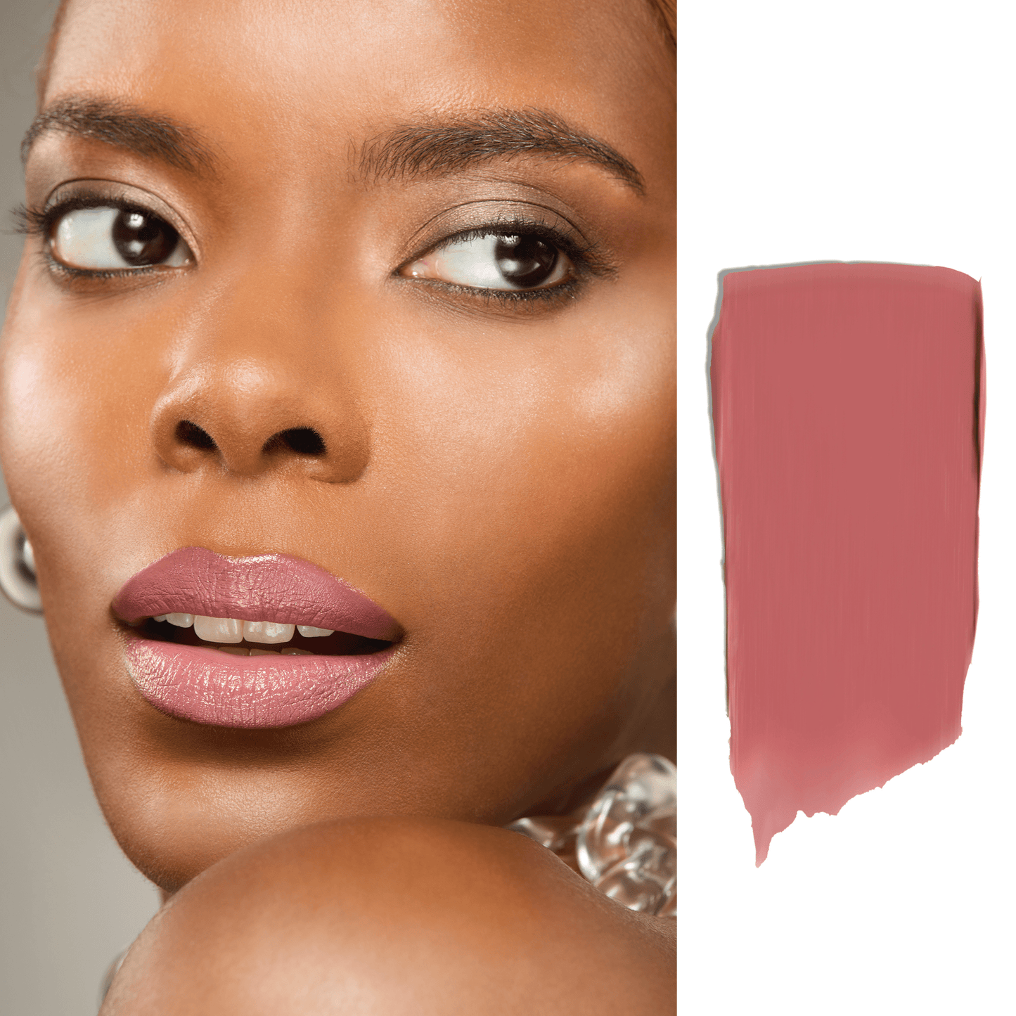 Close-up of a woman's face with a swatch of pink lipstick on a white background