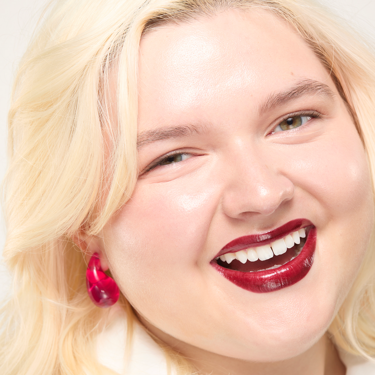 Close-up of a person with blonde hair and red lipstick on a white background