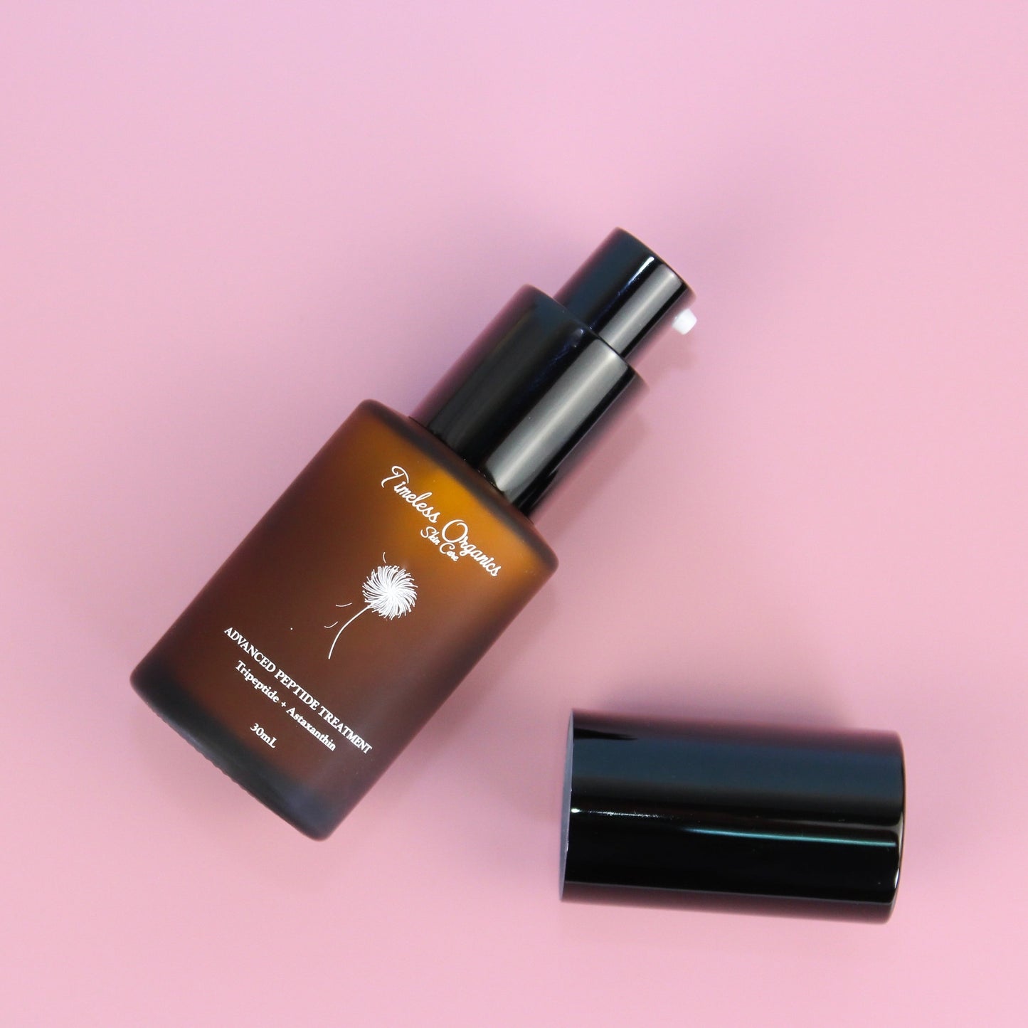 Skincare bottle with dropper on a pink background