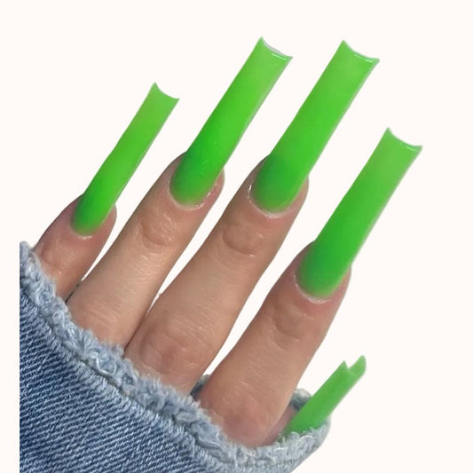 Hand with green acrylic nails on a white background