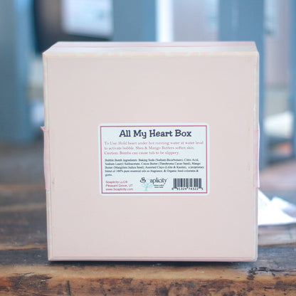 Box labeled 'All My Heart Box' on a wooden surface with a blurred background