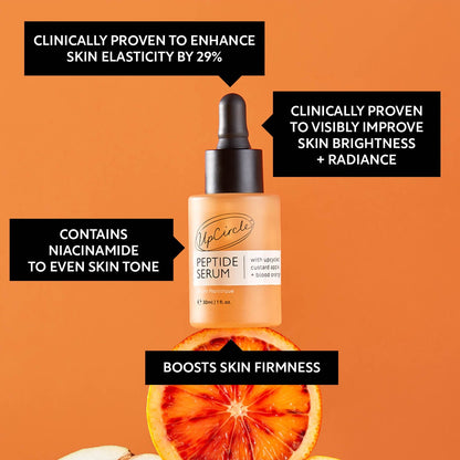 UpCircle Peptide Serum bottle with orange slices on an orange background