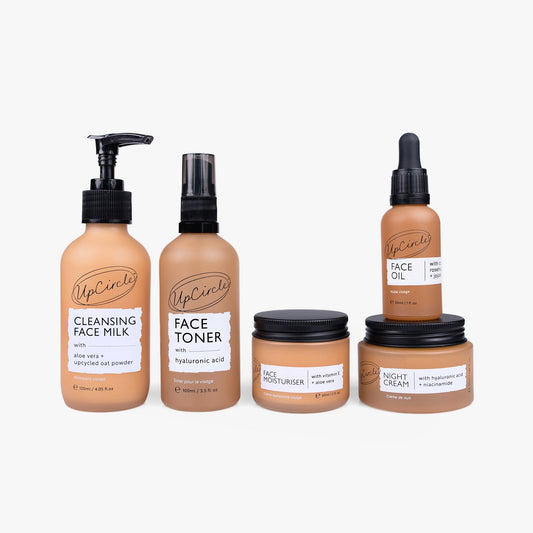 Set of UpCircle skincare products including Cleansing Face Milk, Face Toner, Face Moisturiser, Night Cream, and Face Oil on a white background.